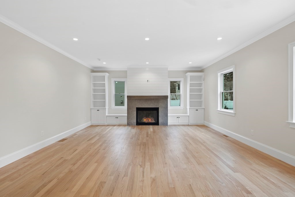28 Hillside Avenue Needham, MA 02494 - Photo 9 of 32 a view of an empty room with wooden floor fireplace and a window