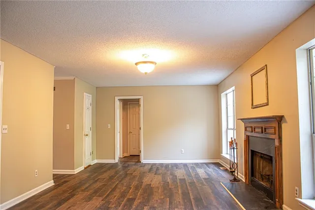 a view of empty room with wooden floor and fireplace