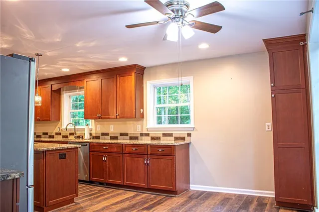 a kitchen with granite countertop a stove cabinets and wooden floor