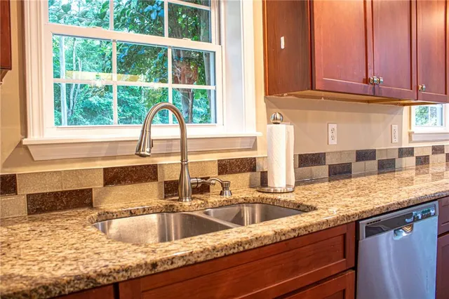 a kitchen with granite countertop a sink and a window