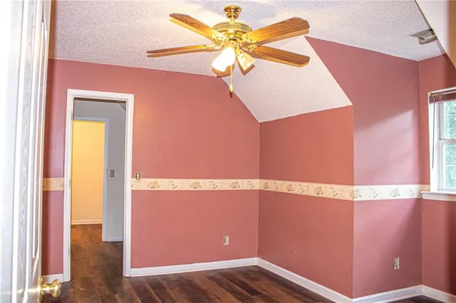 a view of an empty room with window and a chandelier fan