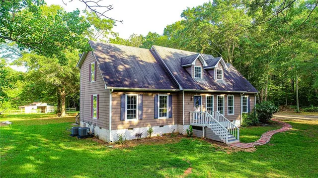 a front view of house with a garden and trees