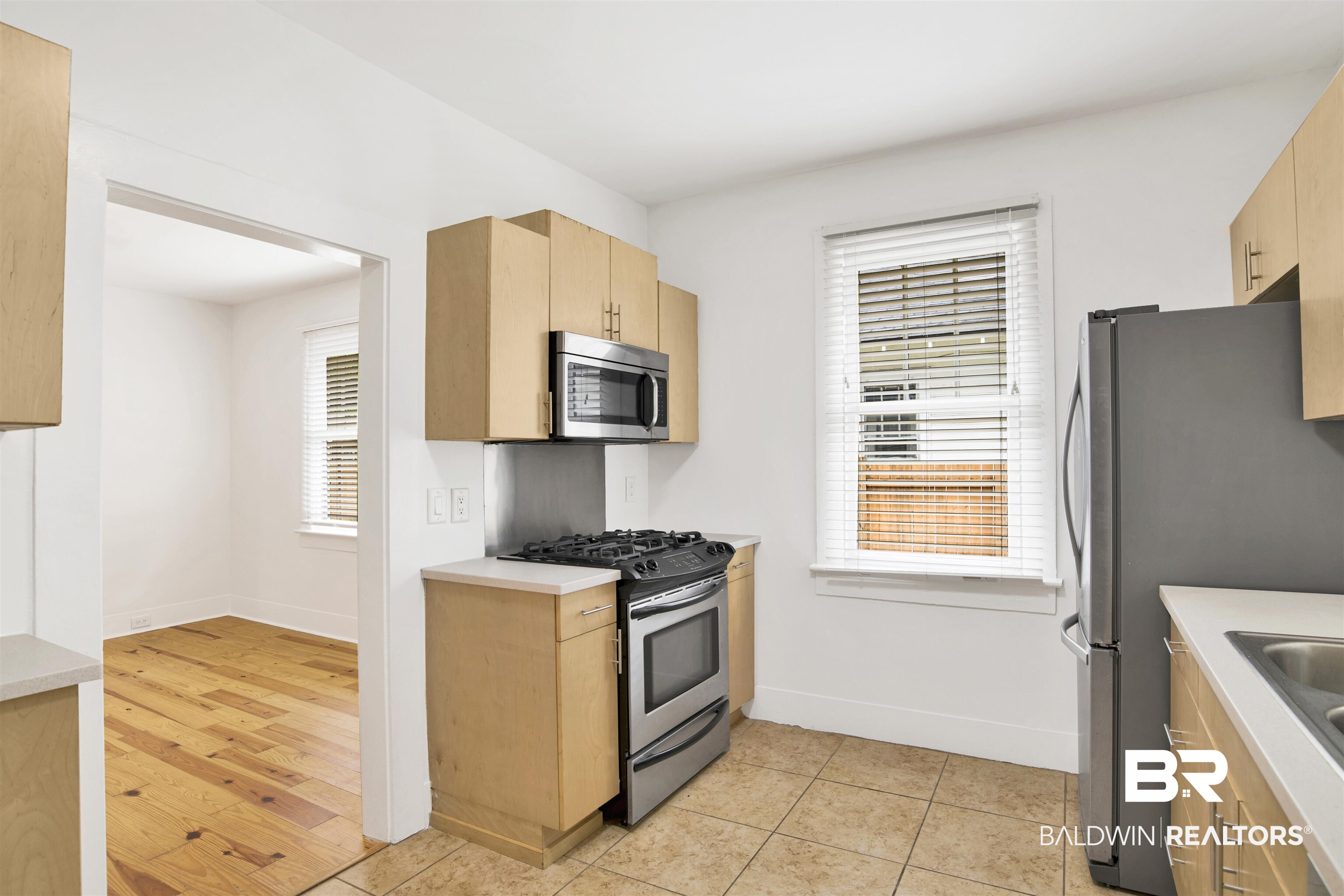 507 Holcombe Avenue Mobile, AL 36606 - Photo 13 of 28 Kitchen with stainless steel appliances, light brown cabinets, light countertops, and baseboards