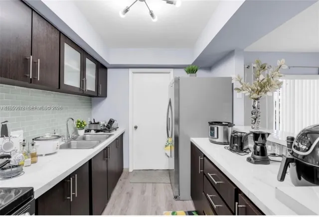 a kitchen with a sink stainless steel appliances and cabinets
