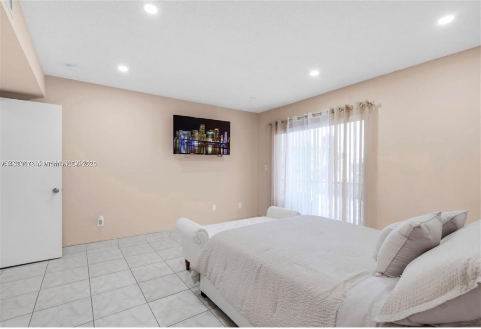 8401 Southwest 107th Avenue, Unit 311E Miami, FL 33173 - Photo 5 of 9 a large white bed in a white room next to a window