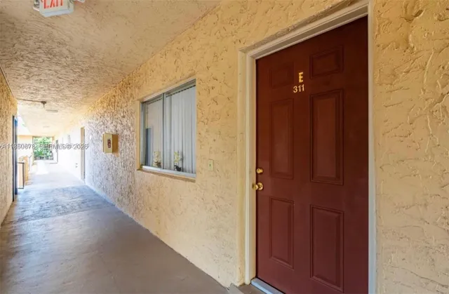a view of a hallway with wooden door