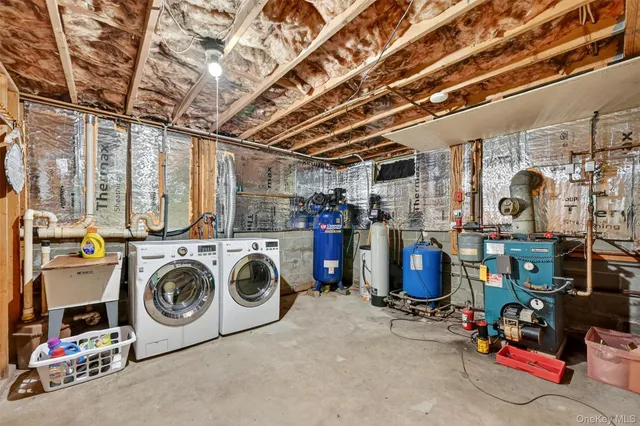 a utility room with dryer washer and a view of living room