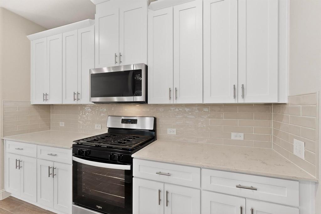 900 Heart Reef Road Plano, TX 75075 - Photo 11 of 40 a kitchen with stainless steel appliances granite countertop white cabinets and a stove