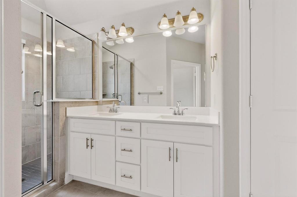900 Heart Reef Road Plano, TX 75075 - Photo 20 of 40 a bathroom with double vanity sinks a vanity a lamp and a mirror