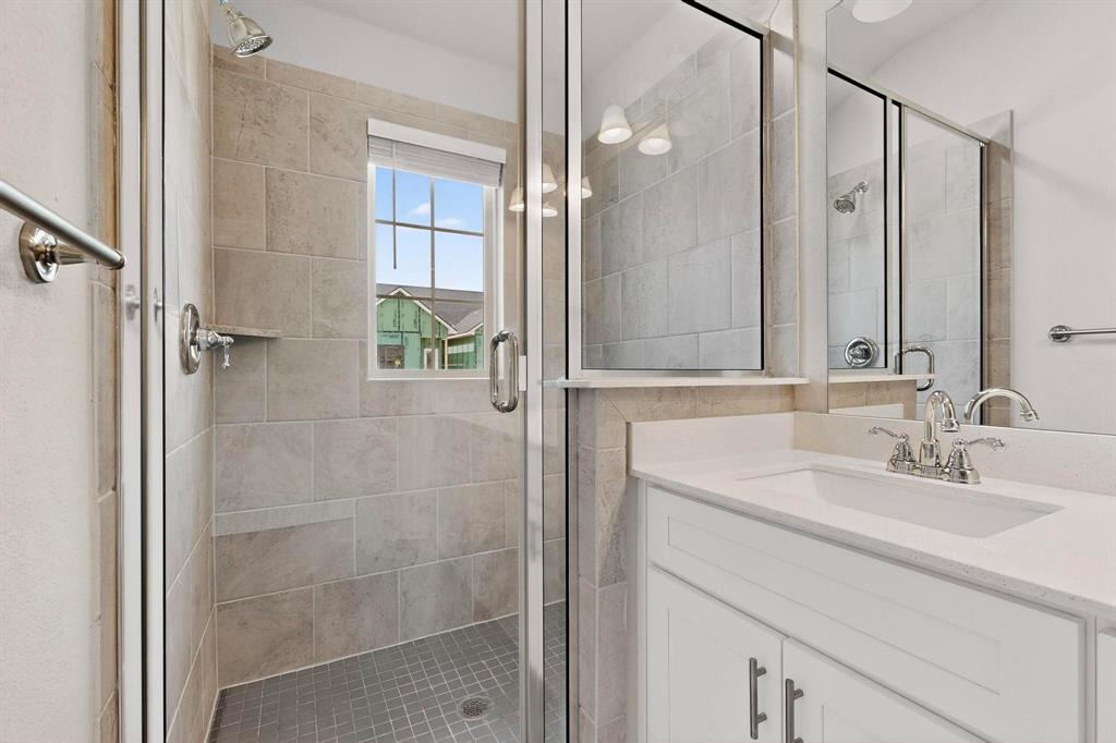 900 Heart Reef Road Plano, TX 75075 - Photo 22 of 40 a bathroom with a shower sink and mirror