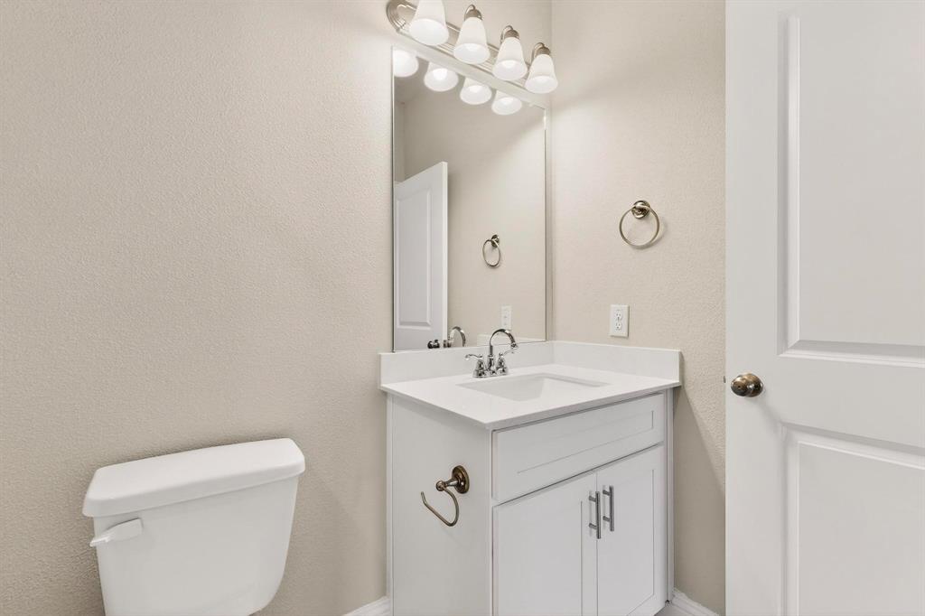 900 Heart Reef Road Plano, TX 75075 - Photo 28 of 40 a bathroom with a toilet a sink and mirror