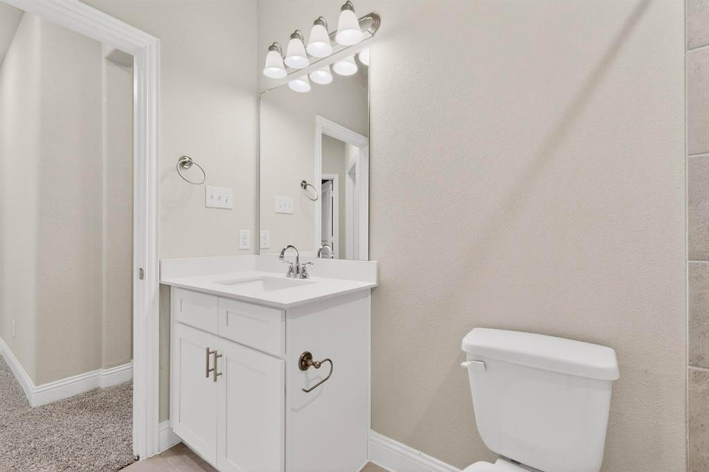900 Heart Reef Road Plano, TX 75075 - Photo 33 of 40 a bathroom with a toilet a sink and mirror