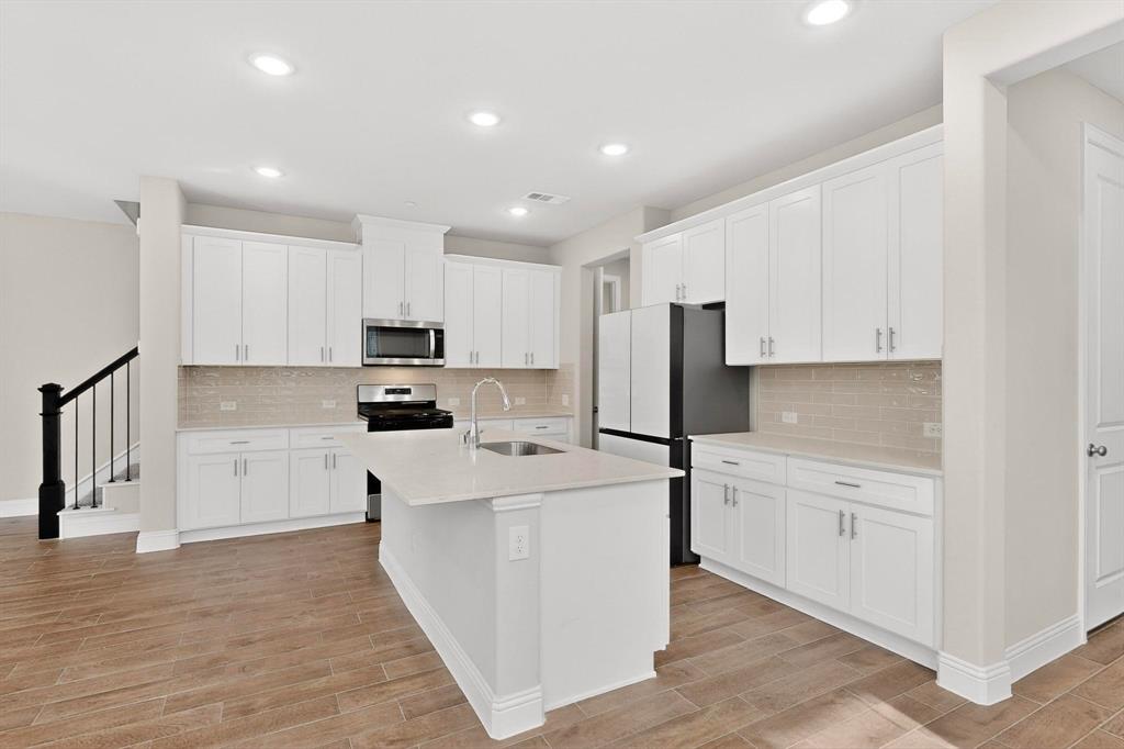900 Heart Reef Road Plano, TX 75075 - Photo 9 of 40 a kitchen with cabinets and wooden floor