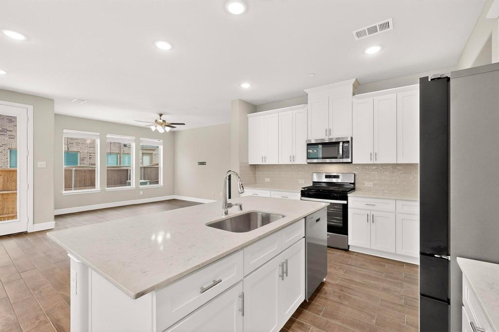 900 Heart Reef Road Plano, TX 75075 - Photo 10 of 40 a kitchen with stainless steel appliances granite countertop a sink stove and refrigerator