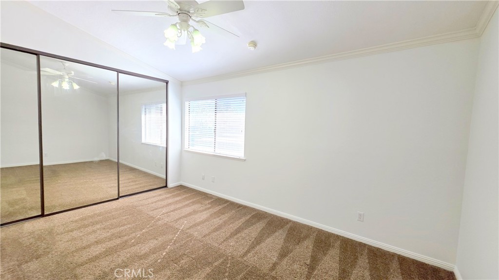 8708 1/2 Pine Crest Place Rancho Cucamonga, CA 91730 - Photo 12 of 22 an empty room with a chandelier fan and windows