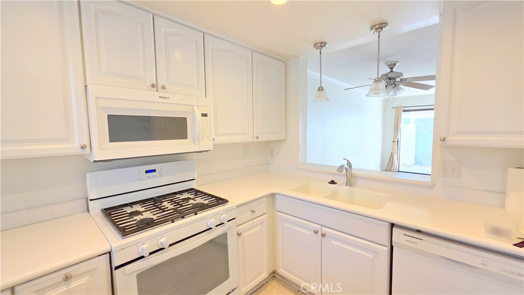 8708 1/2 Pine Crest Place Rancho Cucamonga, CA 91730 - Photo 7 of 22 a kitchen with white cabinets and appliances
