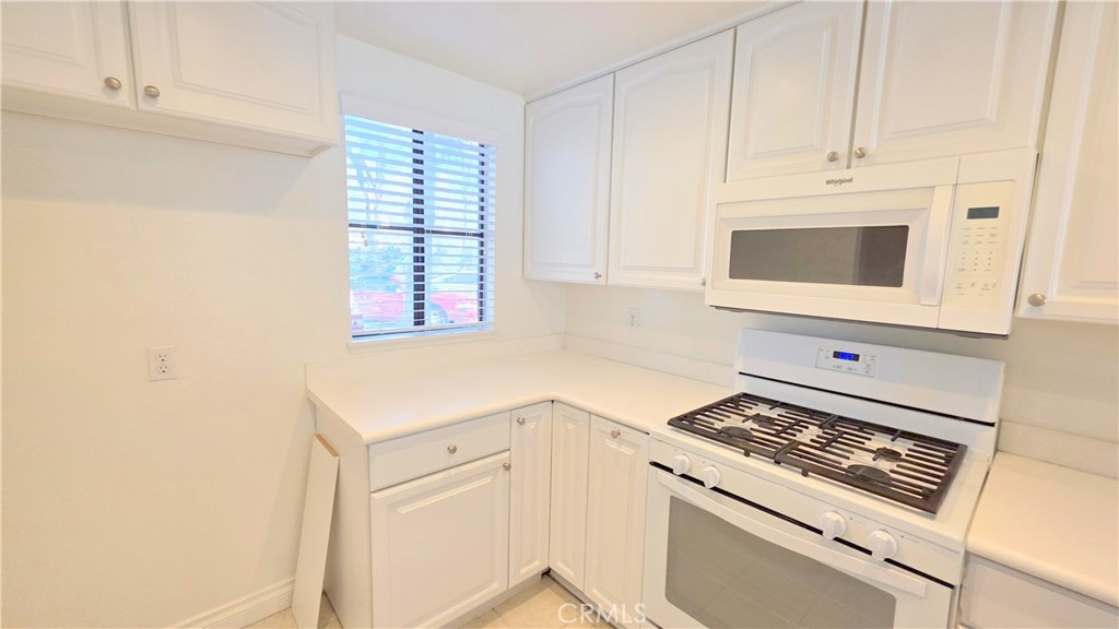 8708 1/2 Pine Crest Place Rancho Cucamonga, CA 91730 - Photo 9 of 22 a kitchen with white cabinets and appliances