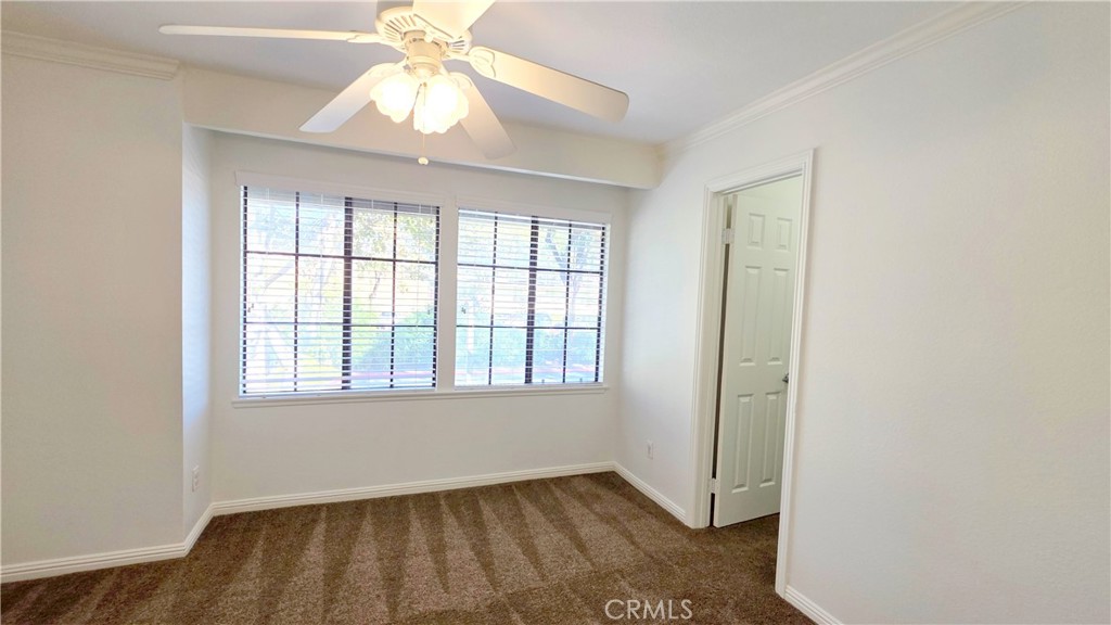 8708 1/2 Pine Crest Place Rancho Cucamonga, CA 91730 - Photo 10 of 22 an empty room with a window and a chandelier fan