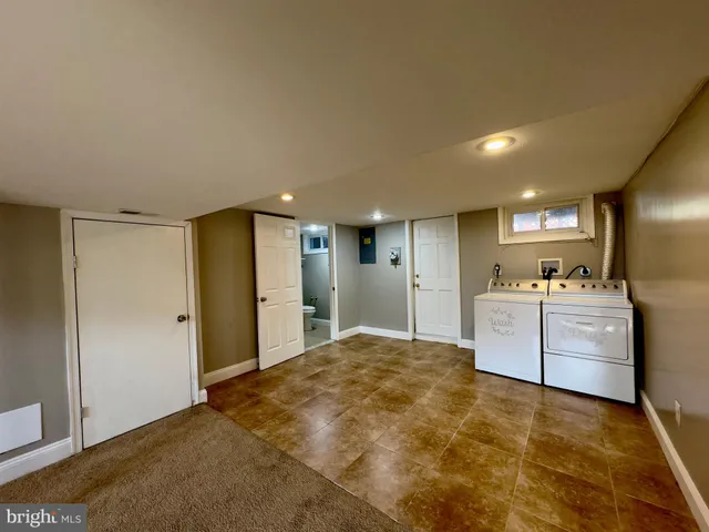 a view of a kitchen with refrigerator and white cabinets