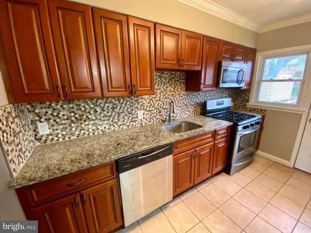 a kitchen with stainless steel appliances granite countertop a sink stove and cabinets