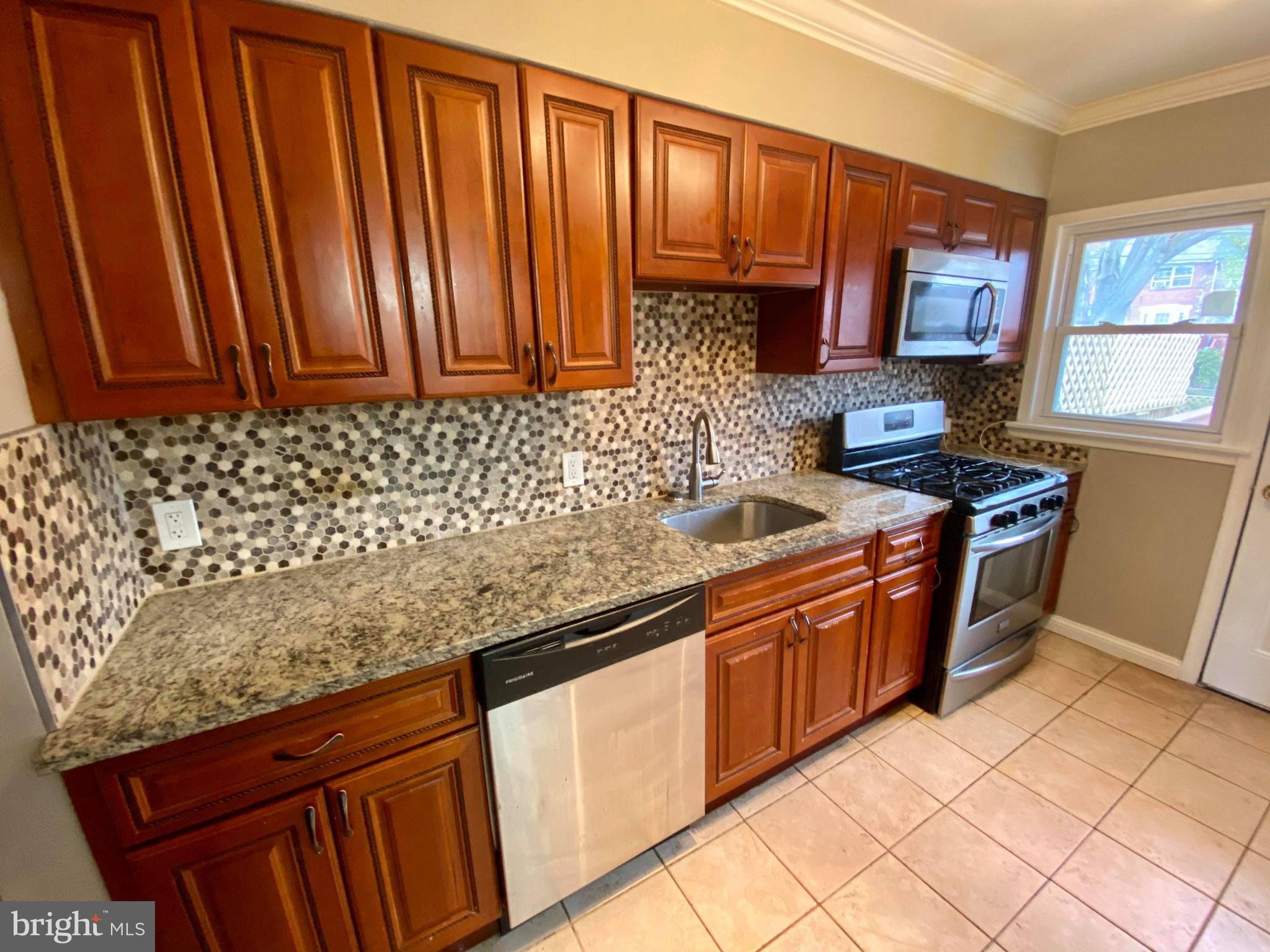 1604 Pentwood Road Baltimore, MD 21239 - Photo 16 of 19 a kitchen with stainless steel appliances granite countertop a sink stove and cabinets