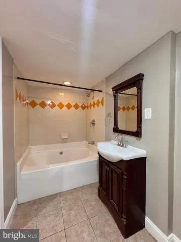 a bathroom with a sink a bathtub and a vanity