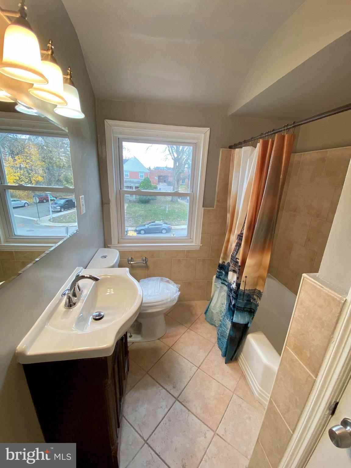 1604 Pentwood Road Baltimore, MD 21239 - Photo 18 of 19 a bathroom with a sink a toilet and mirror