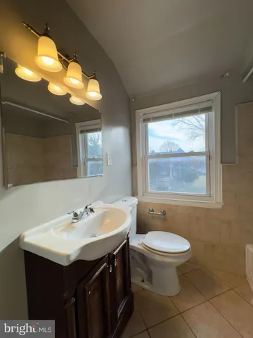 a bathroom with a sink vanity mirror and toilet