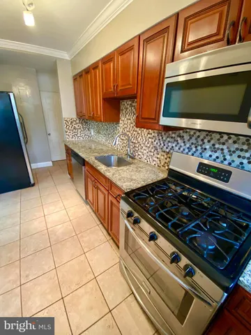 a kitchen with granite countertop a stove and a sink