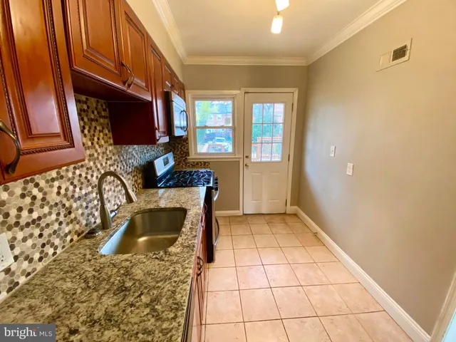 a kitchen with a sink a stove and a microwave