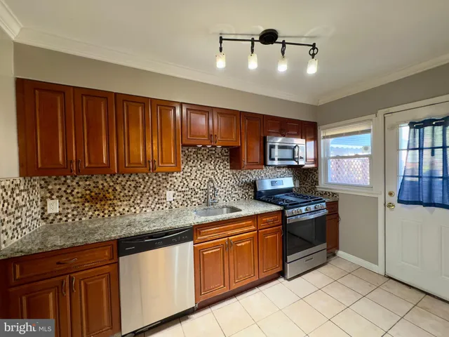 a kitchen with stainless steel appliances granite countertop a stove sink and cabinets