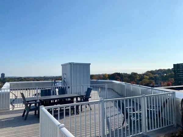 a view of a roof deck with couches and wooden floor