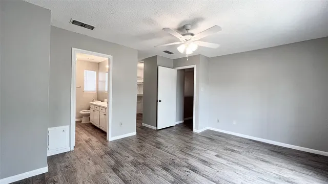 a view of a livingroom with wooden floor and a ceiling fan