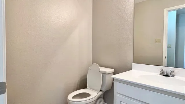 a white toilet sitting next to a white wall