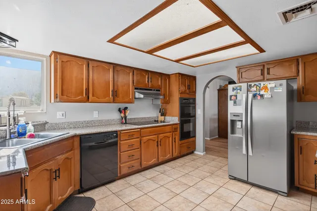 a kitchen with stainless steel appliances granite countertop a sink stove and refrigerator