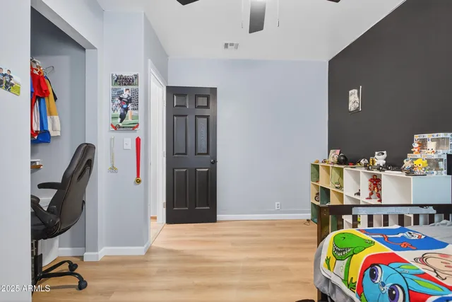 a bedroom with a bed and wooden floor