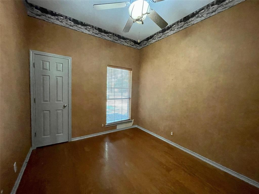 8701 Bellechase Road Granbury, TX 76049 - Photo 11 of 15 an empty room with a chandelier fan and wooden floor