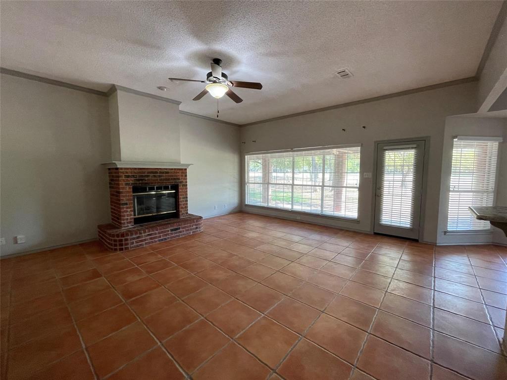 8701 Bellechase Road Granbury, TX 76049 - Photo 2 of 15 a view of an empty room with a fireplace and a window