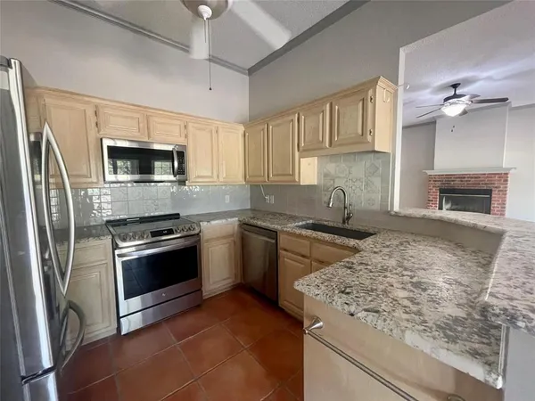 a kitchen with granite countertop a stove sink and microwave