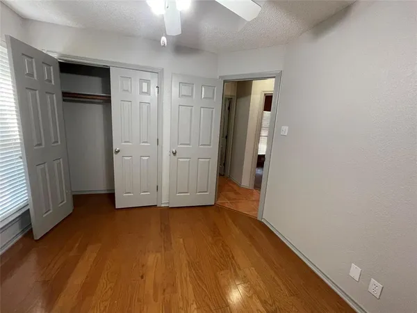 an empty room with wooden floor and closet