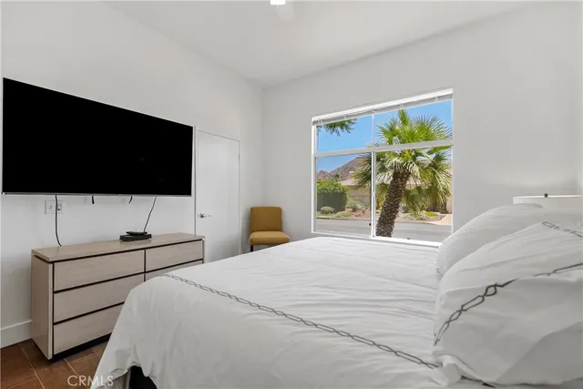 a bedroom with a bed and a flat screen tv
