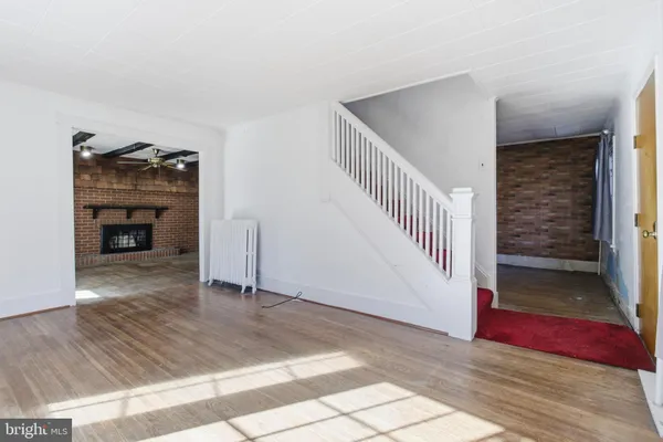 a view of a livingroom with wooden floor and staircase