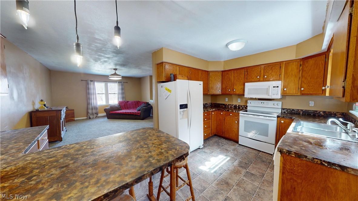 6970 Bushnell Road Conneaut, OH 44030 - Photo 22 of 28 Kitchen with white appliances, tile flooring, pendant lighting, and sink