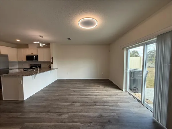 a view of kitchen with wooden floor and electronic appliances