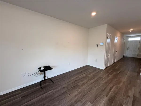 a view of empty room with wooden floor