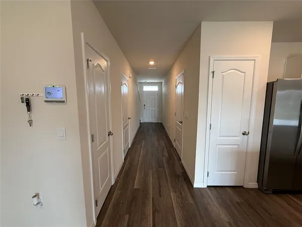a view of a hallway with wooden floor and staircase