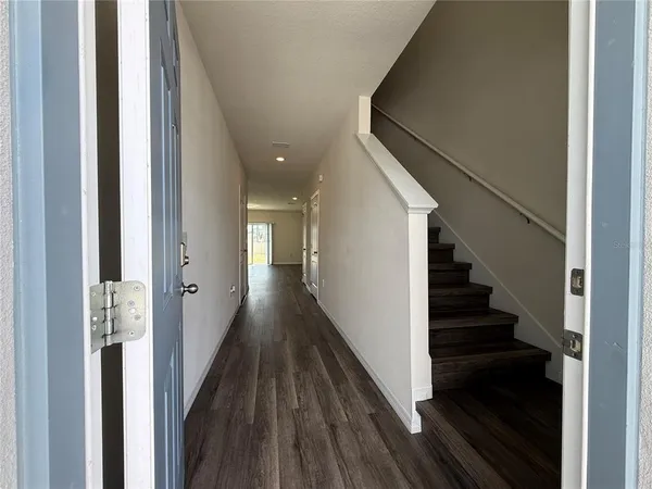 a view of a hallway with wooden floor and staircase
