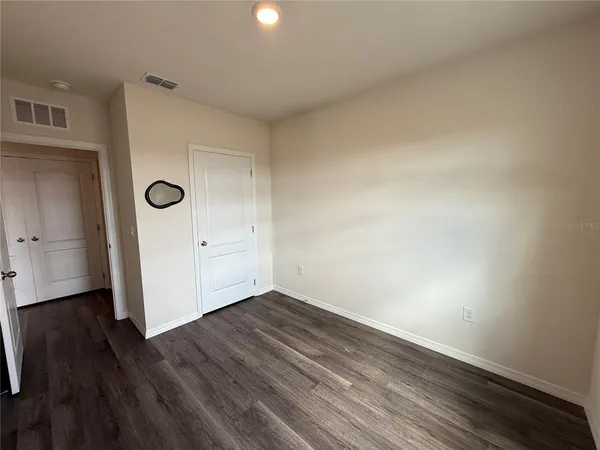 a view of an empty room with wooden floor
