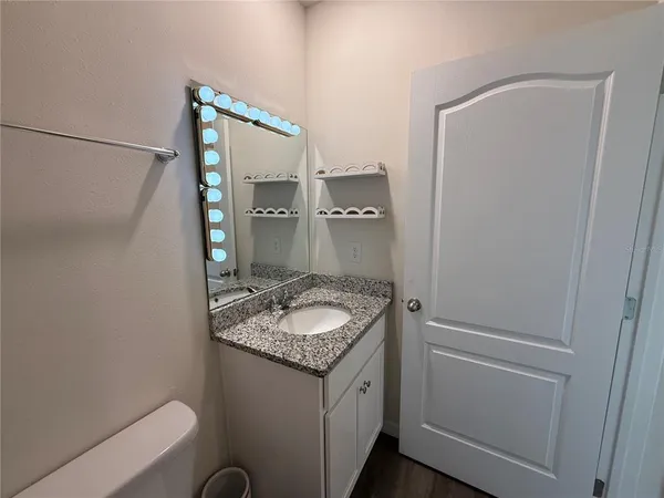 a bathroom with a granite countertop sink and a mirror