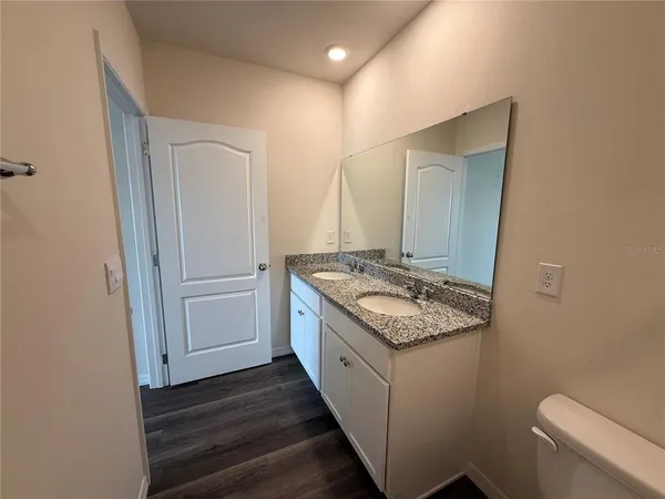a bathroom with a granite countertop sink and a mirror